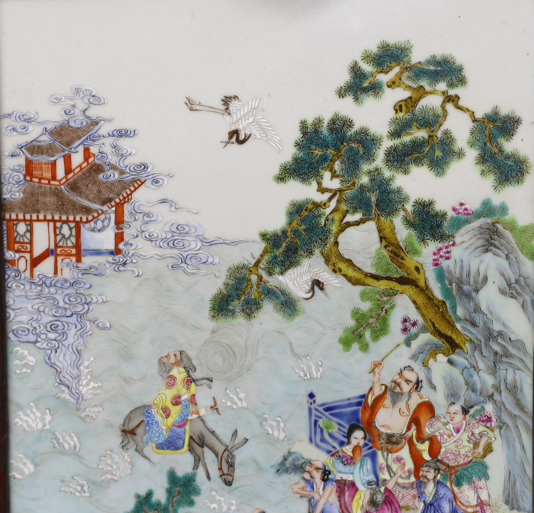 A Chinese enamelled porcelain plaque, decorated with immortals and pagodas in a landscape, framed, overall 47cm x 32cm